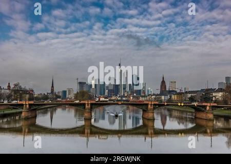 Blick auf Frankfurt bei Sonnenuntergang. Aufnahme mit Hintergrundbeleuchtung und Blick auf die Skyline. Hochhäuser von Banken und Versicherungsgesellschaften im Finanzdistrikt Stockfoto