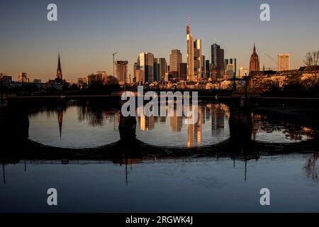 Blick auf Frankfurt bei Sonnenuntergang. Aufnahme mit Hintergrundbeleuchtung und Blick auf die Skyline. Hochhäuser von Banken und Versicherungsgesellschaften im Finanzdistrikt Stockfoto
