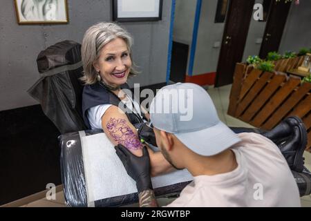 Tattoo-Meister-Tattoo auf Frauenarm Stockfoto