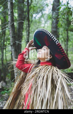 Mexikanische Frau mit Mariachi-Hut und Capisayo oder Umhang aus Palmenblättern. Stockfoto