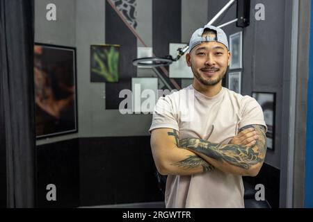 Asiatischer junger Mann in einem Tattoo-Salon Stockfoto