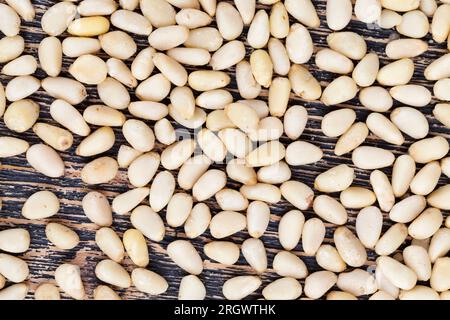 Geschälte Pinienkerne kleiner Größe, nützliche Nüsse, ein Teil der Schale bleibt auf den Zedernüssen Stockfoto