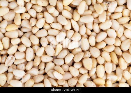 Geschälte Pinienkerne kleiner Größe, nützliche Nüsse, ein Teil der Schale bleibt auf den Zedernüssen Stockfoto