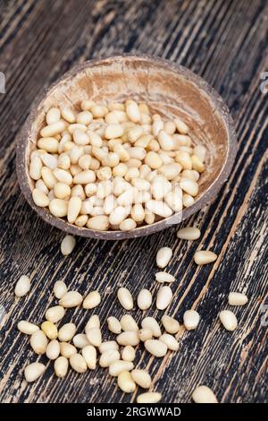 Geschälte Pinienkerne kleiner Größe, nützliche Nüsse, ein Teil der Schale bleibt auf den Zedernüssen Stockfoto