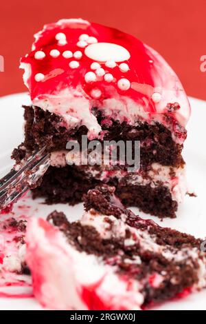 Mehrschichtiger Kuchen aus Kuchen mit Hüttenkäse- und Kastaniengeschmack, Schokoladenkuchen mit Sahne und roter Erdbeermarmelade Stockfoto