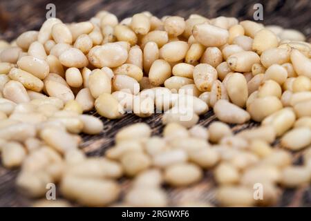 Geschälte Pinienkerne kleiner Größe, nützliche Nüsse, ein Teil der Schale bleibt auf den Zedernüssen Stockfoto