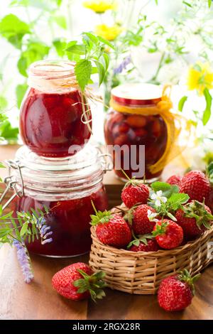 Stillleben mit verschiedenen Arten von Erdbeermarmelade und frischen Erdbeeren Stockfoto