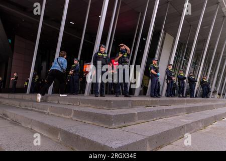 Die Polizei bewacht den Eingang des Gebäudes bei Demonstrationen zur Melbourne Drag Expo im Melbourne Convention Center. Demonstranten und Konterprotestierende stoßen auf divergierende Ideologien über Melbournes Drag Expo. Als das bunte Ereignis zu einem Hintergrund für gesellschaftliche Spannungen wurde, führen leidenschaftliche Demonstranten und Gegenprotestierende Proteste und Zusammenstöße durch. Inmitten dieser beladenen Atmosphäre arbeitete eine beträchtliche Polizeipräsenz, um die Ordnung aufrechtzuerhalten, versuchte, die beiden Gruppen voneinander zu trennen und die öffentliche Sicherheit zu wahren. Stockfoto