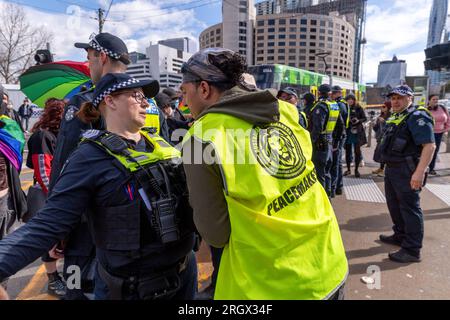 Anti-Trans-Demonstranten konfrontieren die Polizei, während sie Pro-LGBT-Demonstranten von der Straße verlegen, um die beiden Gruppen während der Demonstrationen über die Melbourne Drag Expo im Melbourne Convention Center voneinander zu trennen. Demonstranten und Konterprotestierende stoßen auf divergierende Ideologien über Melbournes Drag Expo. Als das bunte Ereignis zu einem Hintergrund für gesellschaftliche Spannungen wurde, führen leidenschaftliche Demonstranten und Gegenprotestierende Proteste und Zusammenstöße durch. Inmitten dieser beladenen Atmosphäre arbeitete eine beträchtliche Polizeipräsenz, um die Ordnung aufrechtzuerhalten, versuchte, die beiden Gruppen voneinander zu trennen und die öffentliche Sicherheit zu wahren. Stockfoto