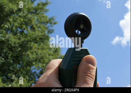 Windgeschwindigkeitsmesser in der Hand eines Mannes. Meteorologie und Klima Stockfoto