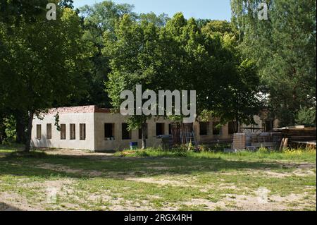 Gebäude ohne Dach. Einstöckiges, unvollendetes Gebäude und Baumaterialien. Lettland 07.2023. Stockfoto
