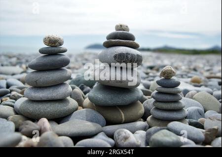 Türme aus Kieselsteinen. Drei Zen-Türme an einem steinigen Strand. Stockfoto