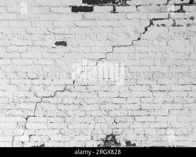 Große lange Wicklung Stufenriss auf altem Putz und lackierter Wand. Schwarzweißfoto. Speicherplatz kopieren. Selektiver Fokus. Stockfoto
