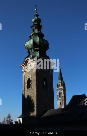 Türme oder Türme von zwei der ältesten Kirchen Salzburgs - das Kloster St. Peter und die Franziskanerkirche, die an einem klaren Wintertag in der Altstadt zu sehen sind Stockfoto