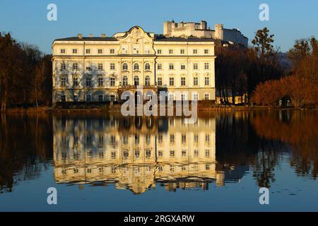 Schloss Leopoldskron und Festung Hohensalzburg zur goldenen Stunde im Spätwinter. Schloss Leopoldskron Seeterrasse mit Blick auf den Kapitelplatz Stockfoto