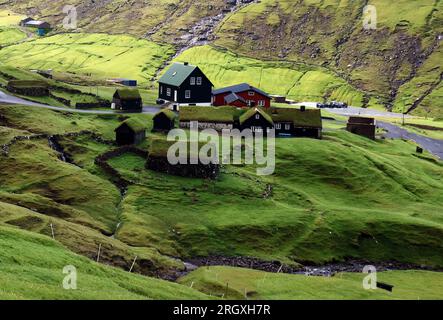 Grüne Berglandschaft mit alten Häusern auf den Färöern, Saksun Stockfoto