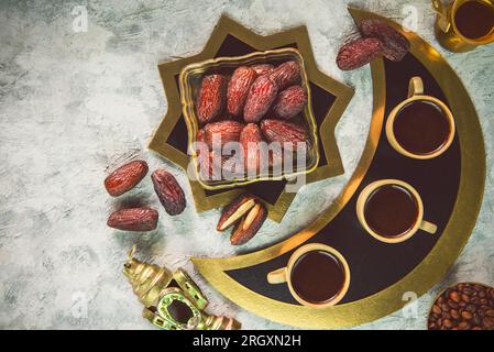 Köstliche Bio-Medjool-Datteln mit türkischen Kaffeetassen, gerösteten Kaffeebohnen und Ramadan-Laterne. Draufsicht mit Kopierbereich. Stockfoto