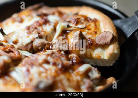 Kleine Mini-Pizza auf Backpapier auf dunklem Holzhintergrund Stockfoto