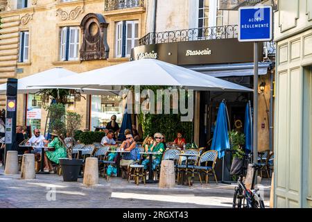 Aix-en-Provence, Frankreich -- 12. August 2023. Leute in einem Straßencafé in Aix-en-Provence. Stockfoto