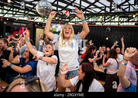 London, Großbritannien. 12. August 2023. Englische Fans im BOXPARK in Shoreditch feiern den Sieg nach der Live-Übertragung des englischen Viertelfinalspiels gegen Kolumbien bei der FIFA Women's World Cup 2023, die in Australien und Neuseeland stattfindet. Endstand 2:1. Kredit: Stephen Chung / Alamy Live News Stockfoto