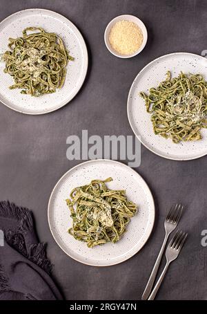 Lebensmittelfotografie von Teigwaren; Tagliatelle, Fettuccine; Trenette; Spinat; Oregano; Parmesan; Käse; Soße, Oliven; Hartweizen, Grieß, Grieß, Gabel bac Stockfoto