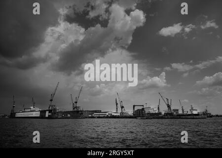 Hamburg, Deutschland - Juni 17 2023: Blohm und Voss Swimming Dock 11 an der Elbe mit Kranen in einer dramatischen schwarz-weißen Stadtlandschaft Stockfoto