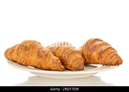 Drei duftende Croissants mit Schokoladenfüllung auf einer weißen Keramikplatte, Nahaufnahme, isoliert auf Weiß. Stockfoto