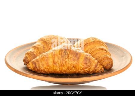 Drei duftende Croissants mit Schokoladenfüllung auf einem Teller Lehm, Nahaufnahme, isoliert auf Weiß. Stockfoto