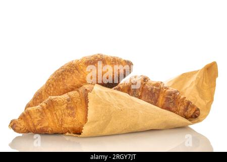 Drei duftende Croissants mit Schokoladenfüllung und einer Tüte Handwerkspapier, Nahaufnahme, isoliert auf Weiß. Stockfoto