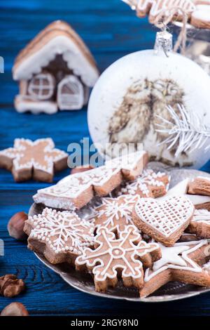 Weihnachten Neujahr Lebkekse und Weihnachtsball auf blauem Holzhintergrund. Stockfoto