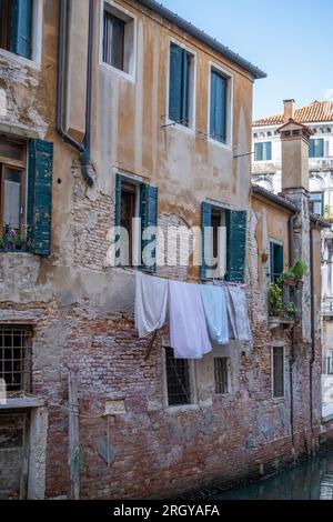 Wäscheservice zum Trocknen an Seilen über dem Kanal in Venedig Stockfoto