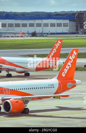 London, England, Vereinigtes Königreich - 1. August 2023: Heckflossen von Airbus A320 Passagierflugzeugen, die von der Billigfluggesellschaft easyjet am Flughafen London Gatwick betrieben werden Stockfoto