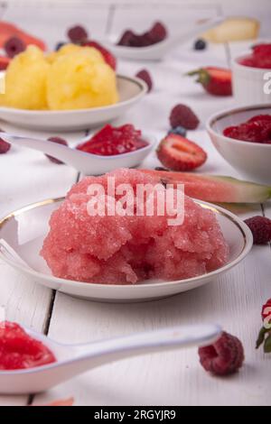 Eisfrucht und Beerensorbet. Assornment Wassermelone, Heidelbeere, Himbeere, Heidelbeere; Erdbeere, Melonensorbet auf weißem Holzhintergrund. Stockfoto