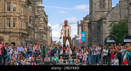 Royal Mile, Edinburgh, Schottland, Großbritannien. 12. August 2023. Edinburgh Festival Fringe, Straßenkünstler in der High Street, die ein großes Publikum aufführen, windig für Jongleure auf Plattformen, Sonnenschein und gelegentlich heftige Duschen. Pictured Reidiculous jongliert mit verschiedenen Instrumenten, die auf seiner Plattform in der windigen High Street stehen. Kredit: Archwhite/alamy Live News. Stockfoto