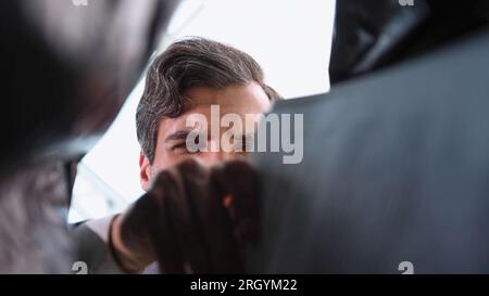 Ein Geschäftsmann nimmt einen Ordner aus einer Plastiktüte. Ansicht von unten Stockfoto