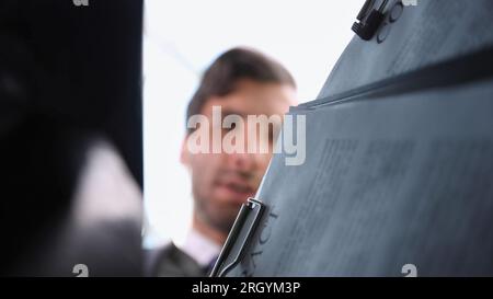 Ein Geschäftsmann nimmt einen Ordner aus einer Plastiktüte. Stockfoto