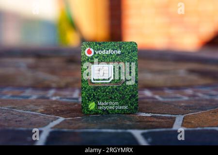 Vodafone SIM-Karte aus recyceltem Kunststoff. Nahaufnahme mit unscharfem Hintergrund und Kopierbereich. Stafford, Großbritannien, 12. August 2023 Stockfoto