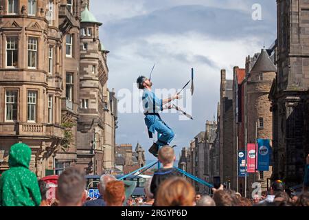 Royal Mile, Edinburgh, Schottland, Großbritannien. 12. August 2023. Edinburgh Festival Fringe, Straßenkünstler in der High Street, die vor einem großen Publikum auftreten, windig für diejenigen, die auf Plattformen jonglieren, Sonnenschein und gelegentliche starke Dusche. Anrede: Archwhite Stockfoto