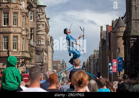 Royal Mile, Edinburgh, Schottland, Großbritannien. 12. August 2023. Edinburgh Festival Fringe, Straßenkünstler in der High Street, die vor einem großen Publikum auftreten, windig für diejenigen, die auf Plattformen jonglieren, Sonnenschein und gelegentliche starke Dusche. Anrede: Archwhite Stockfoto