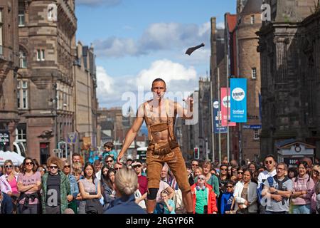 Royal Mile, Edinburgh, Schottland, Großbritannien. 12. August 2023. Edinburgh Festival Fringe, Straßenkünstler in der High Street, die ein großes Publikum aufführen, windig für Jongleure auf Plattformen, Sonnenschein und gelegentlich heftige Duschen. Pictured Reidiculous jongliert mit verschiedenen Instrumenten, die auf seiner Plattform in der windigen High Street stehen. Kredit: Archwhite/alamy Live News. Stockfoto