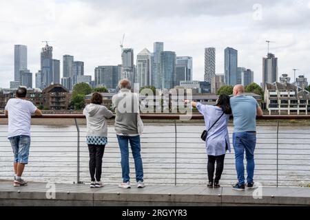 London, Großbritannien. 12. August 2023. Die Menschen genießen den Blick auf das Finanzviertel von Canary Wharf, aus der Sicht von Greenwich. Die Immobilienentwicklerin Canary Wharf Group (CWG) erklärte, dass sich die CWG angesichts der hohen Zahl unbesetzter Büroflächen, des geplanten Umzugs von HSBC in die ehemalige Hauptniederlassung von BT in der Nähe von St. Paul's, anderen Finanzunternehmen, die ihre Belegung verringern und von zu Hause aus arbeiten, stärker auf Wissenschaft, Einzelhandel und Wohnungswesen konzentrierte. Kredit: Stephen Chung / Alamy Live News Stockfoto