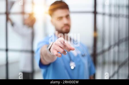 Arzt zeigt mit dem Finger in der Lobby des Krankenhauses Stockfoto