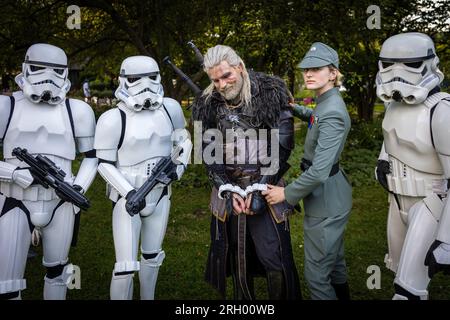 Cottbus, Deutschland. 12. Aug. 2023. Eine Offizierin der kaiserlichen Streitkräfte, unterstützt von Stormtroopers (alle aus der Star Wars Saga), fesselte den bekannten Cosplayer Maul Cosplay, mit dem echten Namen Ben Bergmann, beim Elbenwald Festival. Das Elbenwald Festival ist ein dreitägiges Treffen für Menschen jeden Alters, die Filme, Fantasie, Spiele, Konzerte und eine beliebige Kombination von allem genießen. Die Organisatoren erwarten etwa 15.000 Besucher. Kredit: Frank Hammerschmidt/dpa/Alamy Live News Stockfoto