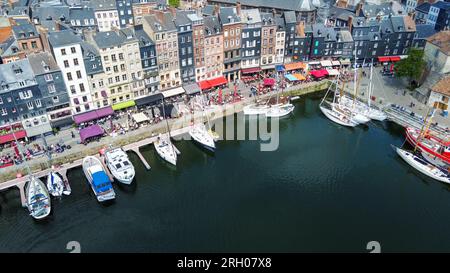 Fantastischer Blick auf die Drohne auf die normandische antike Stadt Honfleut mit Hafen von Segelbooten und Fischerbooten. Und Cafés im Freien und Menschen sittinf Stockfoto