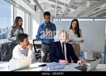 Mitarbeiter des internationalen Business Teams arbeiten im Tagungsraum mit Laptop. Stockfoto