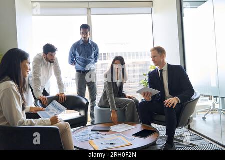 Vielfältige Mitarbeiter im Team sprechen in der Lobby des Firmenbüros. Stockfoto