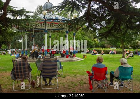 Music in the Park - Priory Park, Southend-on-Sea, Essex, Großbritannien. 12/08/2023. Menschen jeden Alters entspannen sich am Bühnenstand im Priory Park und lauschen den musikalischen Klängen der Variety Jazz Band. Der Bandstand im Priory Park ist ein beliebter Veranstaltungsort in der Gemeinde, wo die Massen wieder einmal ein Sommerprogramm mit kostenlosen Musikaufführungen genießen, die jedes Jahr die Massen anziehen. Helen Cowles/Alamy Live News. Stockfoto