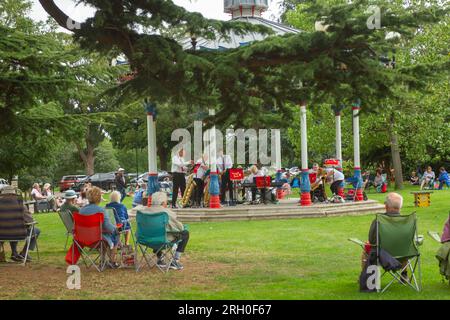 Music in the Park - Priory Park, Southend-on-Sea, Essex, Großbritannien. 12/08/2023. Menschen jeden Alters entspannen sich am Bühnenstand im Priory Park und lauschen den musikalischen Klängen der Variety Jazz Band. Der Bandstand im Priory Park ist ein beliebter Veranstaltungsort in der Gemeinde, wo die Massen wieder einmal ein Sommerprogramm mit kostenlosen Musikaufführungen genießen, die jedes Jahr die Massen anziehen. Helen Cowles/Alamy Live News. Stockfoto