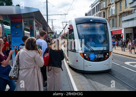 Öffentliche Wartezeit bis zum Einsteigen in die Straßenbahn auf der Princes Street in Edinburgh, Schottland, Großbritannien Stockfoto