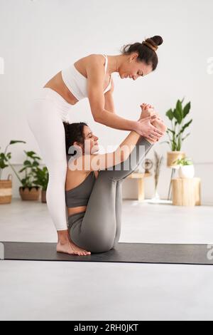 Zwei junge Weiße, die zusammen Yoga machen. Personal Trainer, Student. Stockfoto